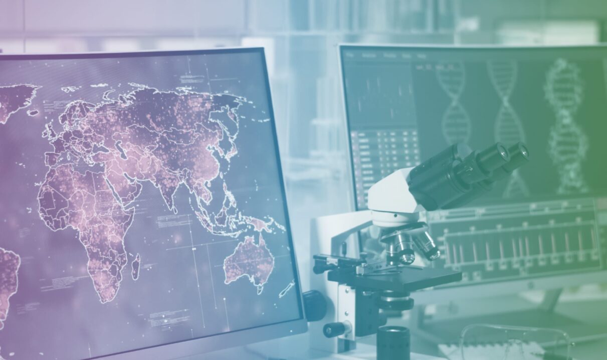 An image of two monitors; one shows a world map, the other displays data, with a microscope situated between them