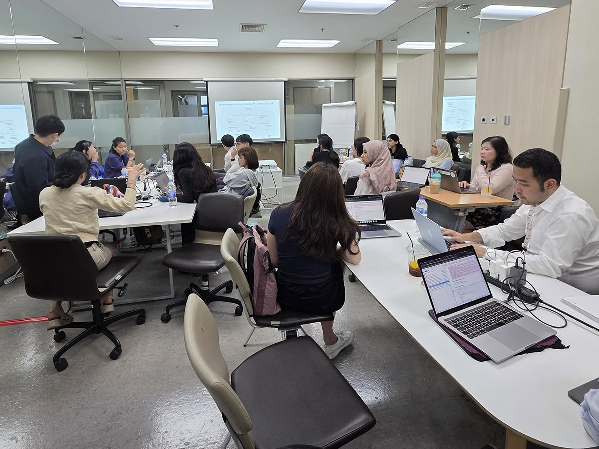 Researchers work collaboratively on laptops during a workshop.