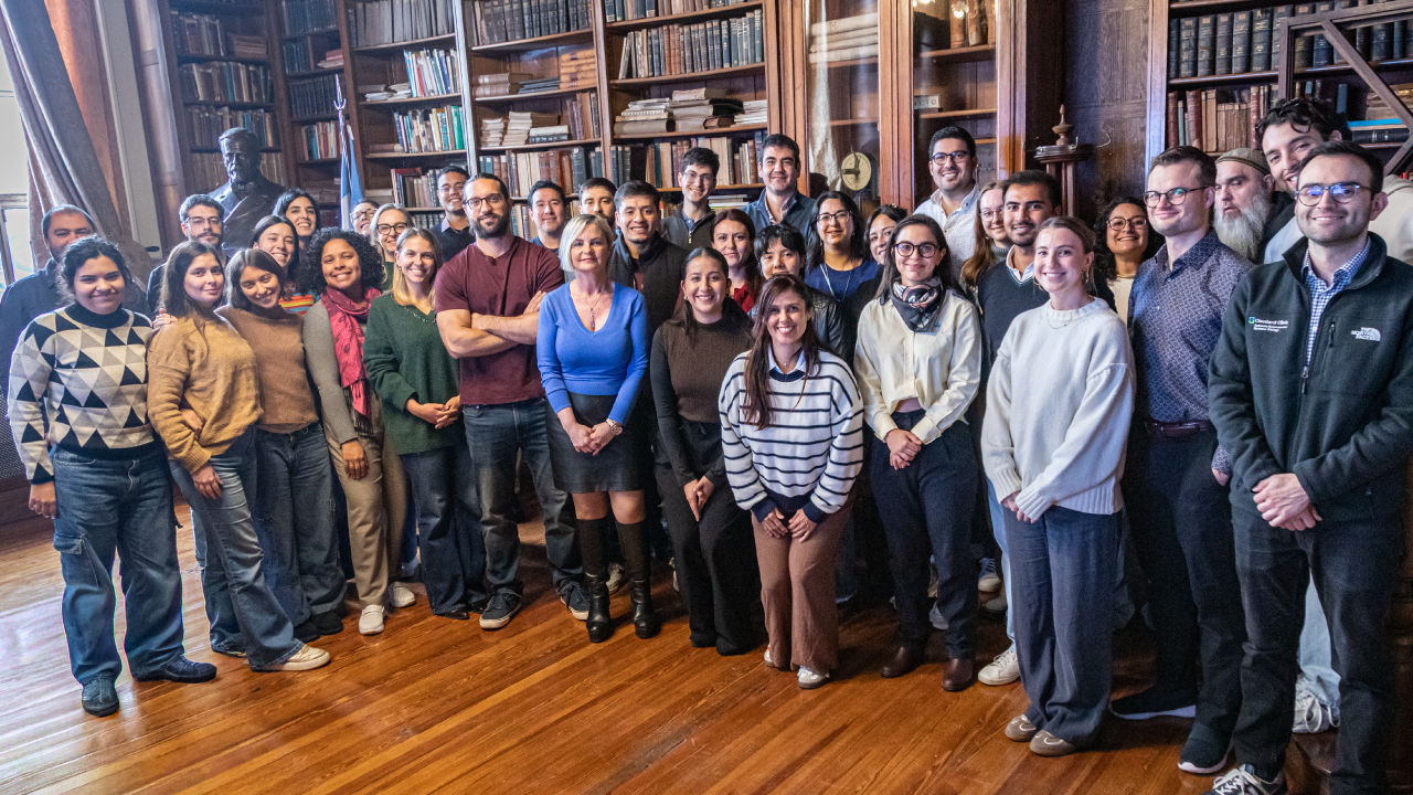 Group photo of participants at the GP2 Bioinformatics Workshop in Buenos Aires, standing in front of wooden bookshelves.